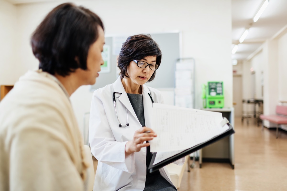 woman talking to her doctor in the waiting room with forms