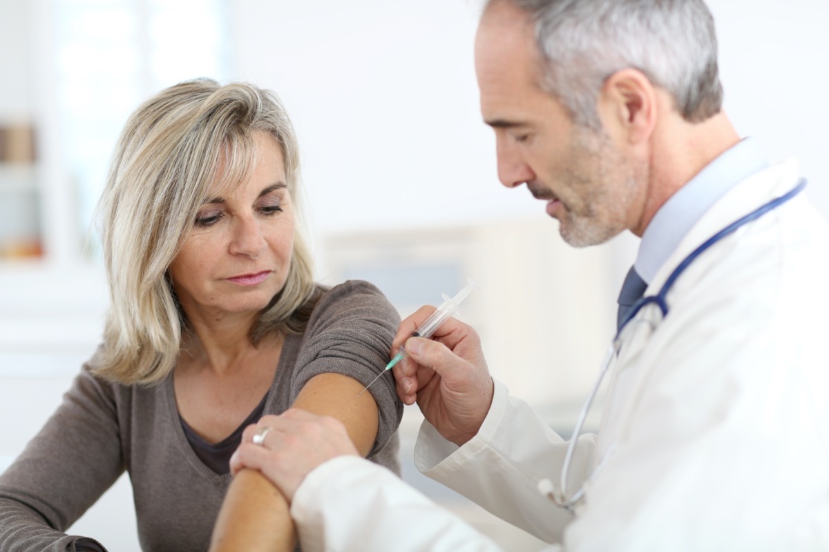 Doctor injecting vaccine to senior woman