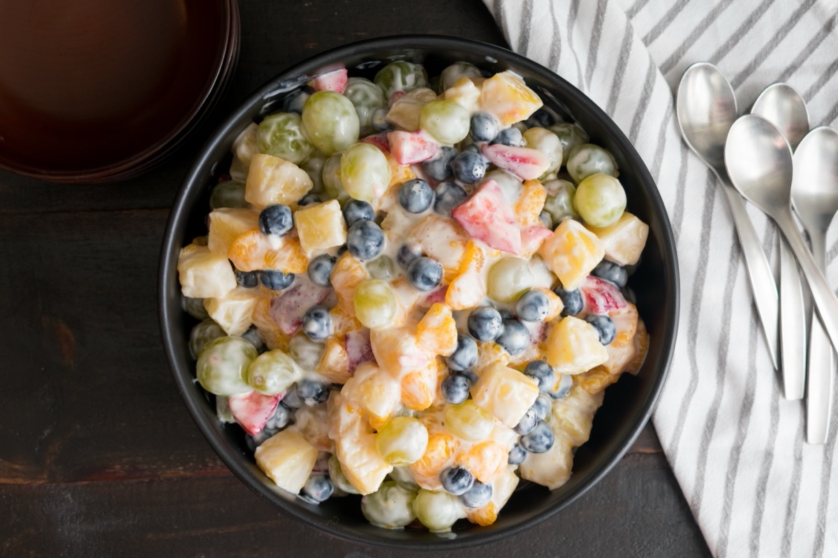 fruit salad made with mayonnaise or yogurt in a black bowl