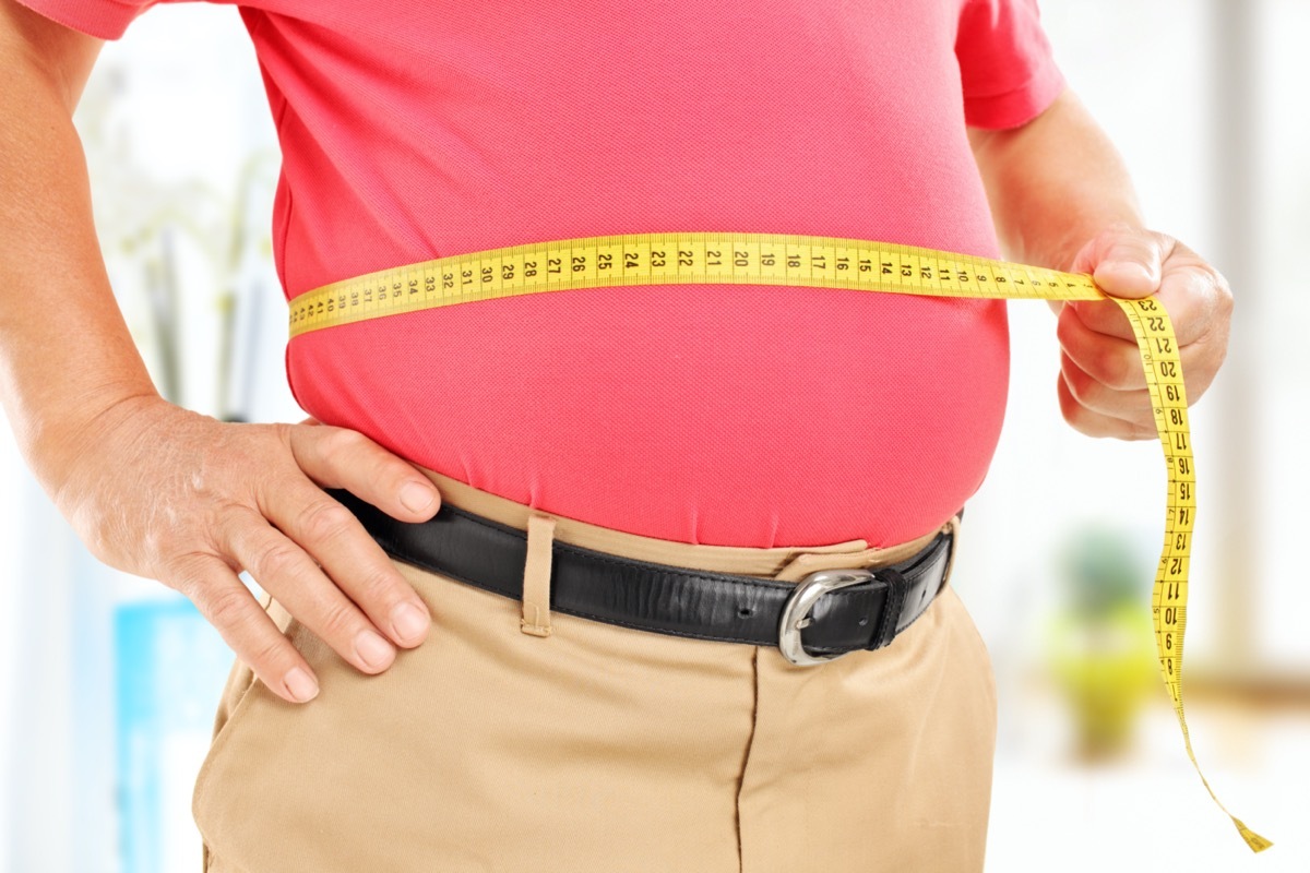 man measuring his belly at home.