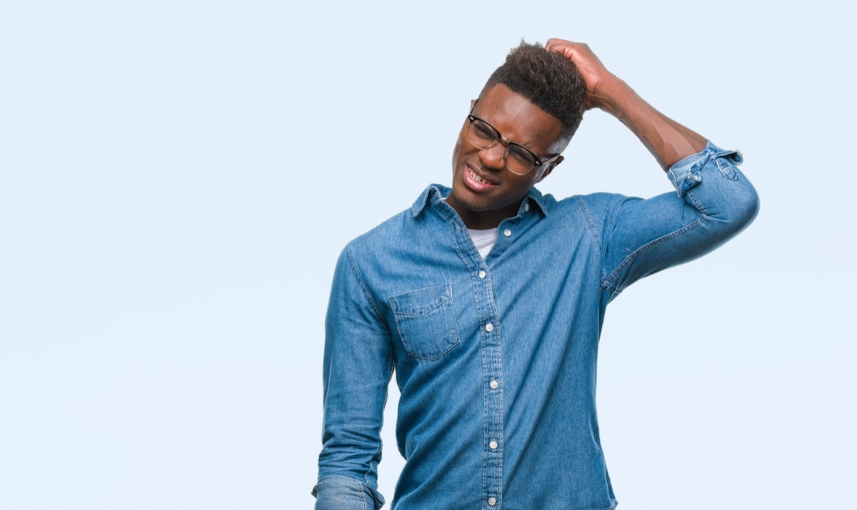 man scratching his head while attempting to complete a logic puzzle