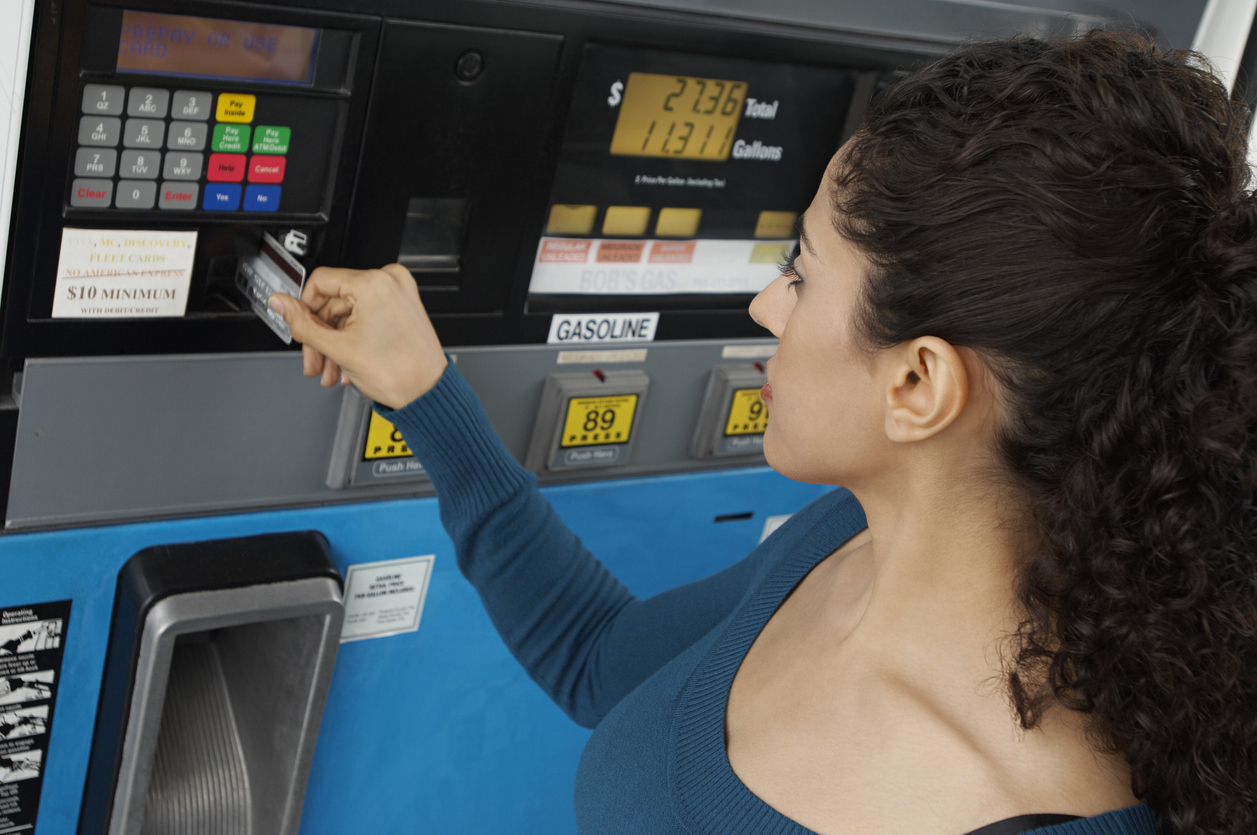 A person paying for gas at the pump using a credit card