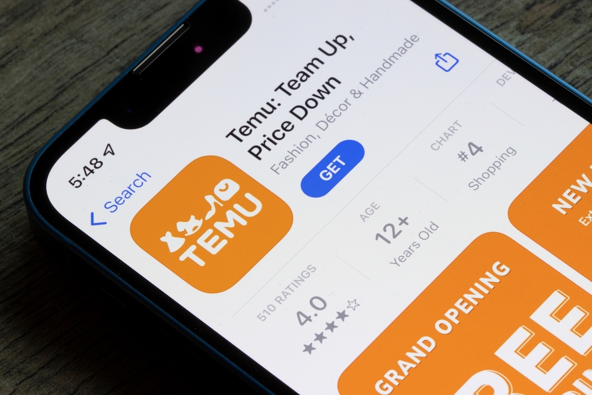 a cell phone screen shows someone downloading Temu, the popular ecommerce app