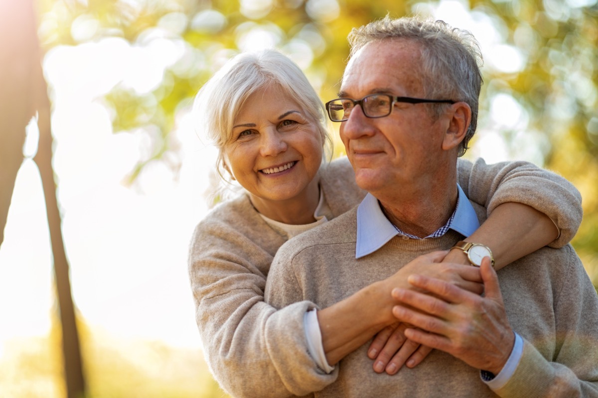 mature man and woman embracing in an autumn park