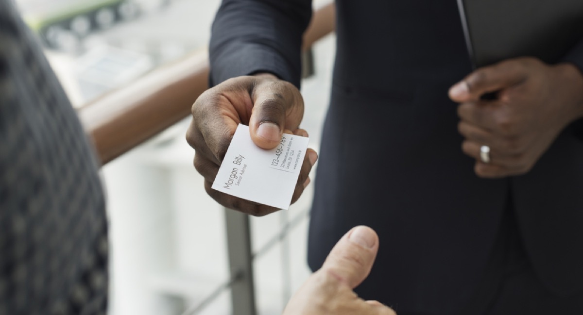 woman offering coworker her business card, office etiquette