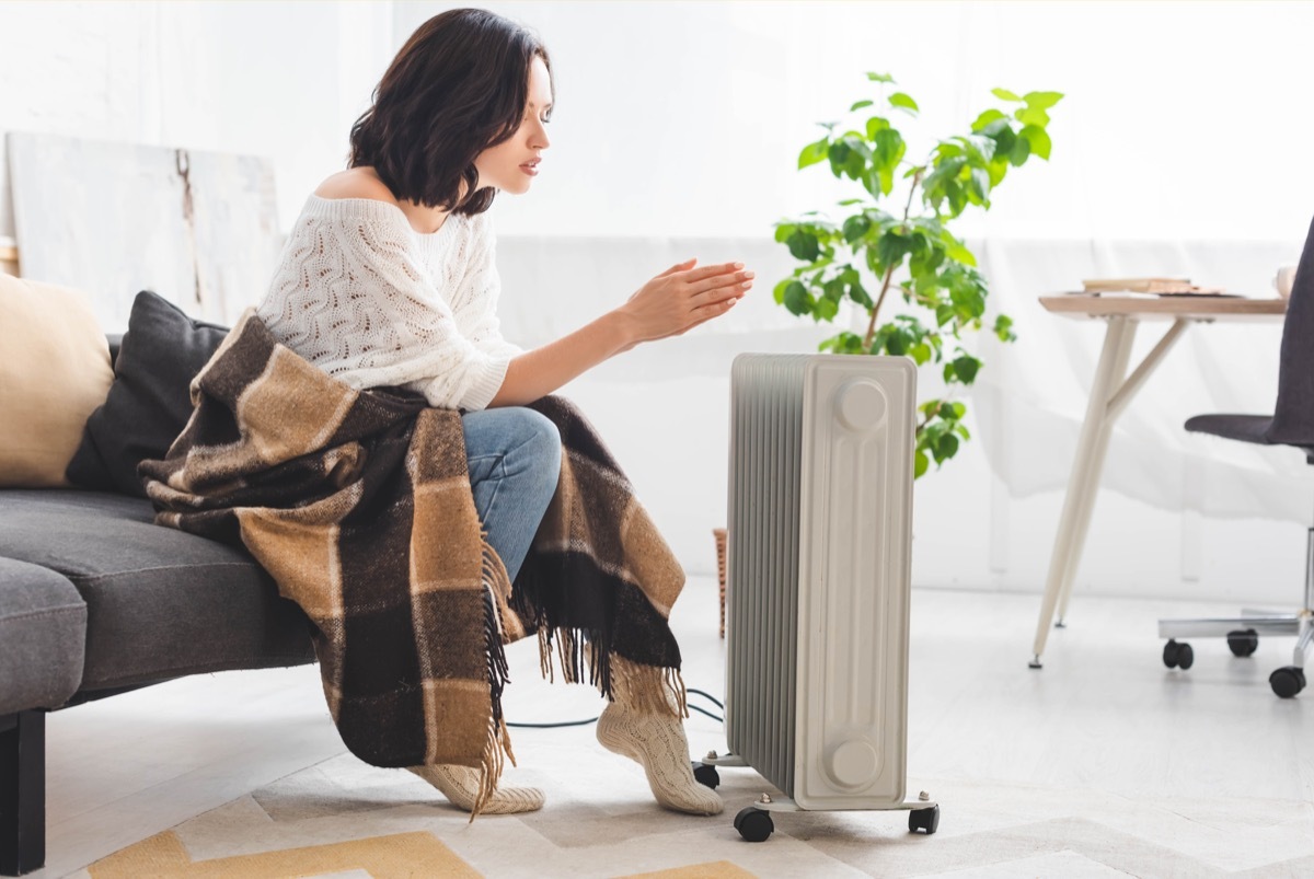 woman warming up next to a space heater