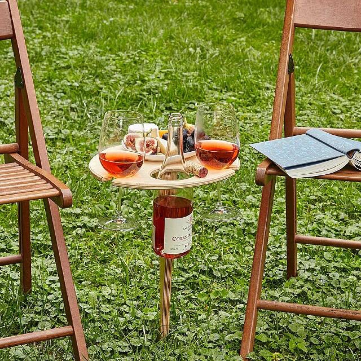 wine on wooden table and chairs on grass