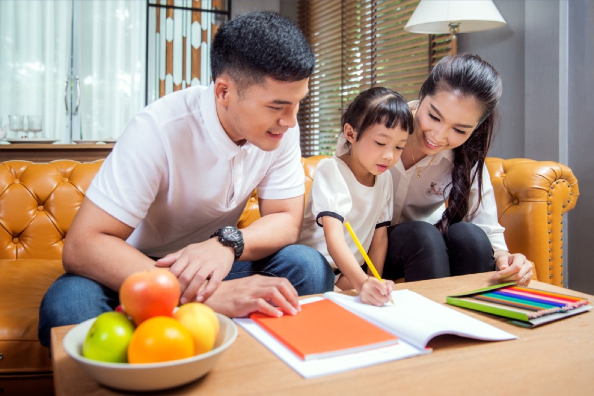 asian parents helping young child with homework being a step-parent