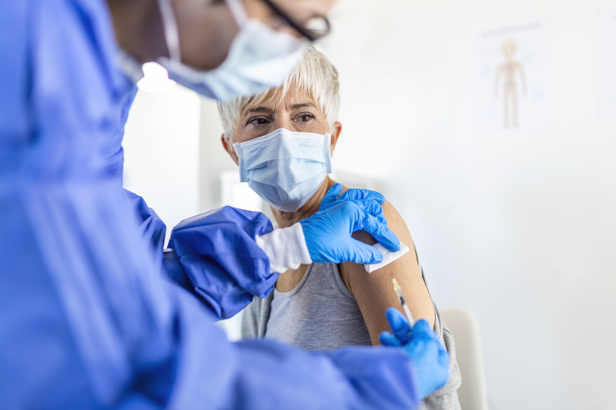 A senior woman receiving a COVID-19 vaccine or booster shot