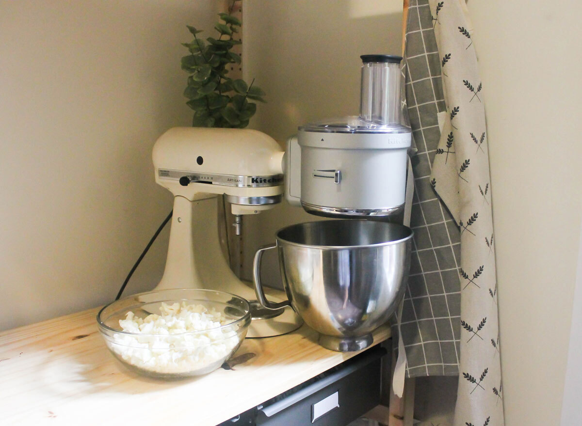 Kitchen Aid food processor on a counter with cauliflower ready to rice