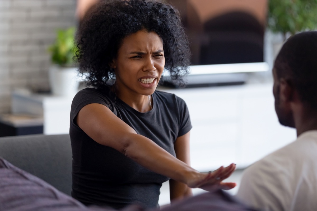 Upset woman holds up her hand to keep man away