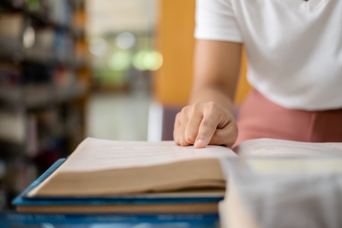 young woman searching for cool words in the dictionary