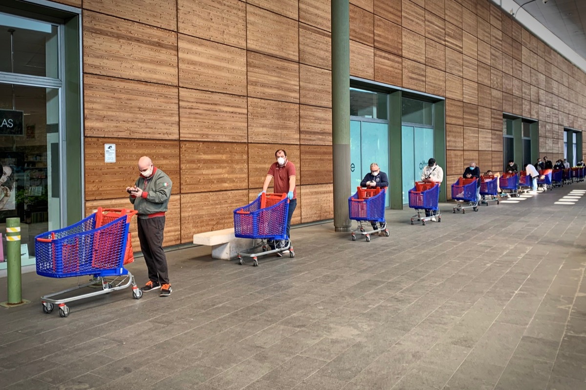 shoppers waiting on line to get into supermarket