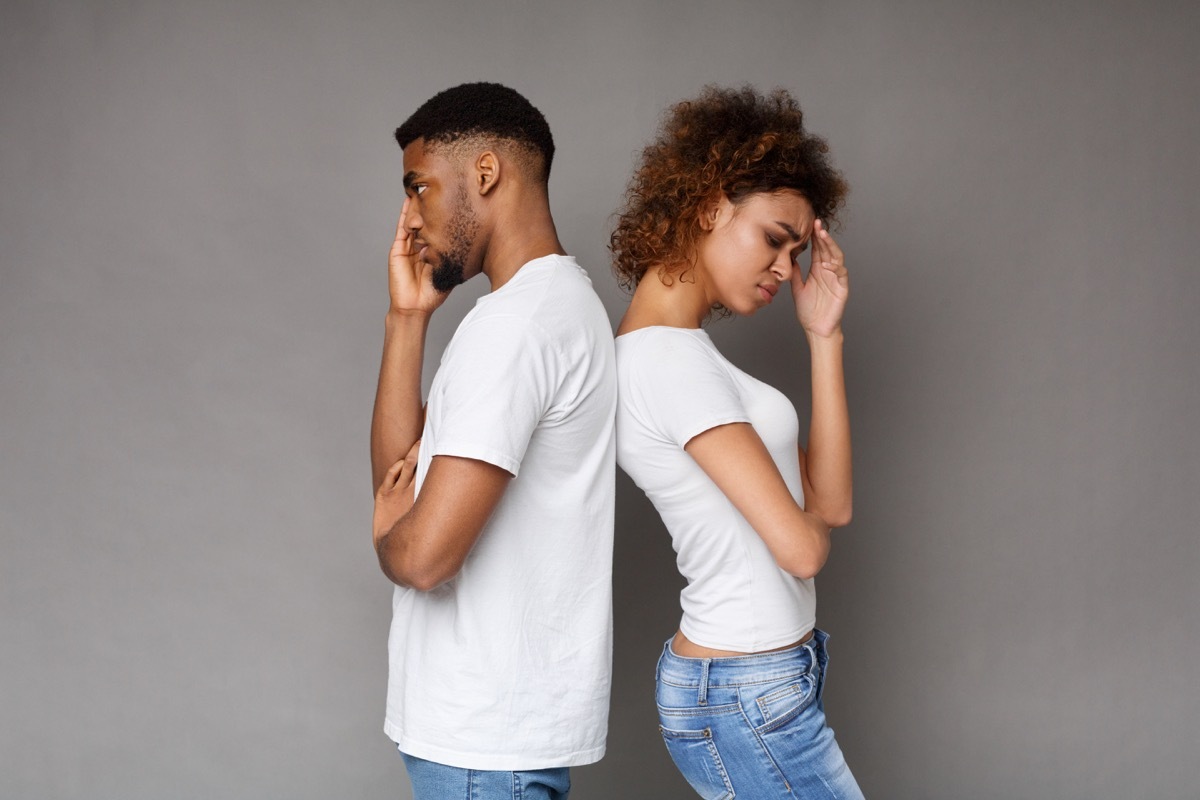 unhappy man and woman standing back to back