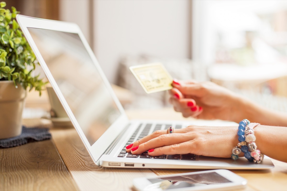 woman shopping online with a laptop and a credit card, reach a customer service rep