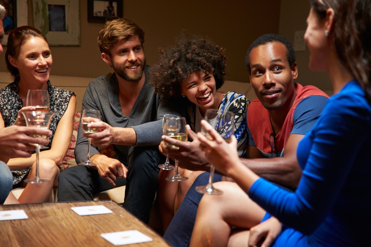 Group of friends sitting around a table at house party