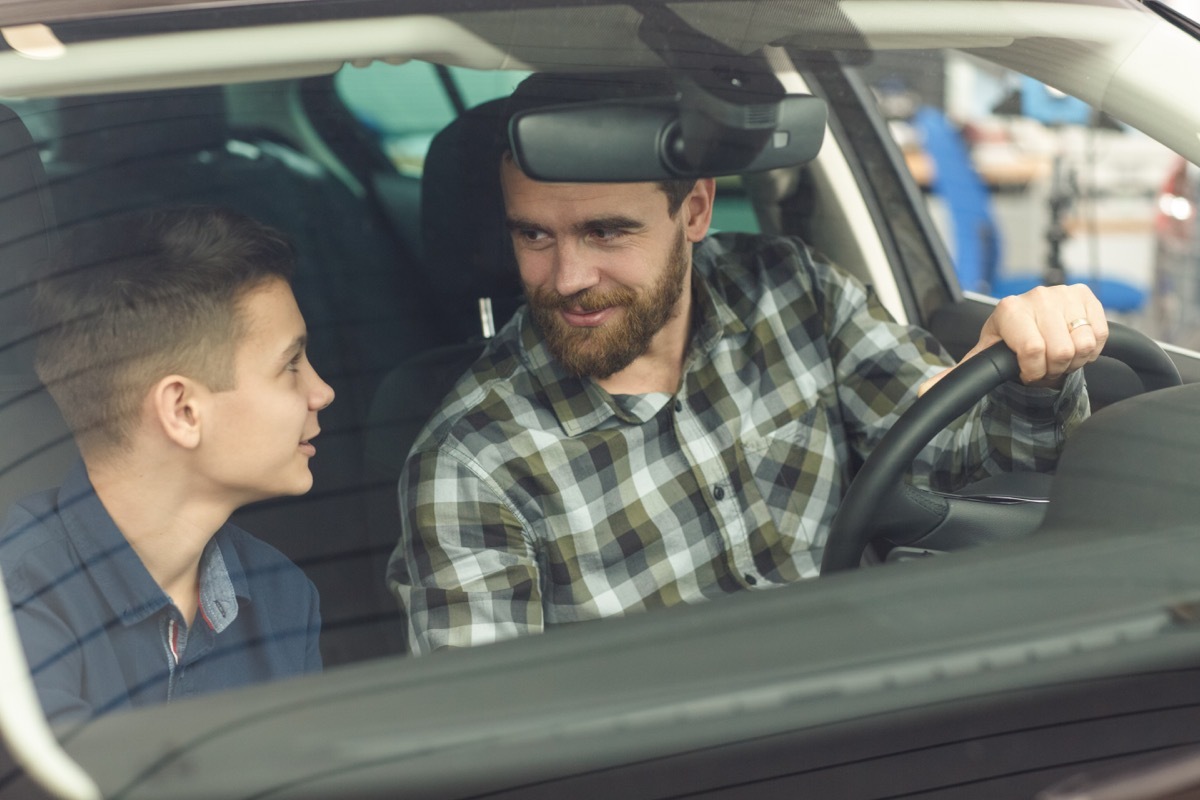 white father and son talking in car