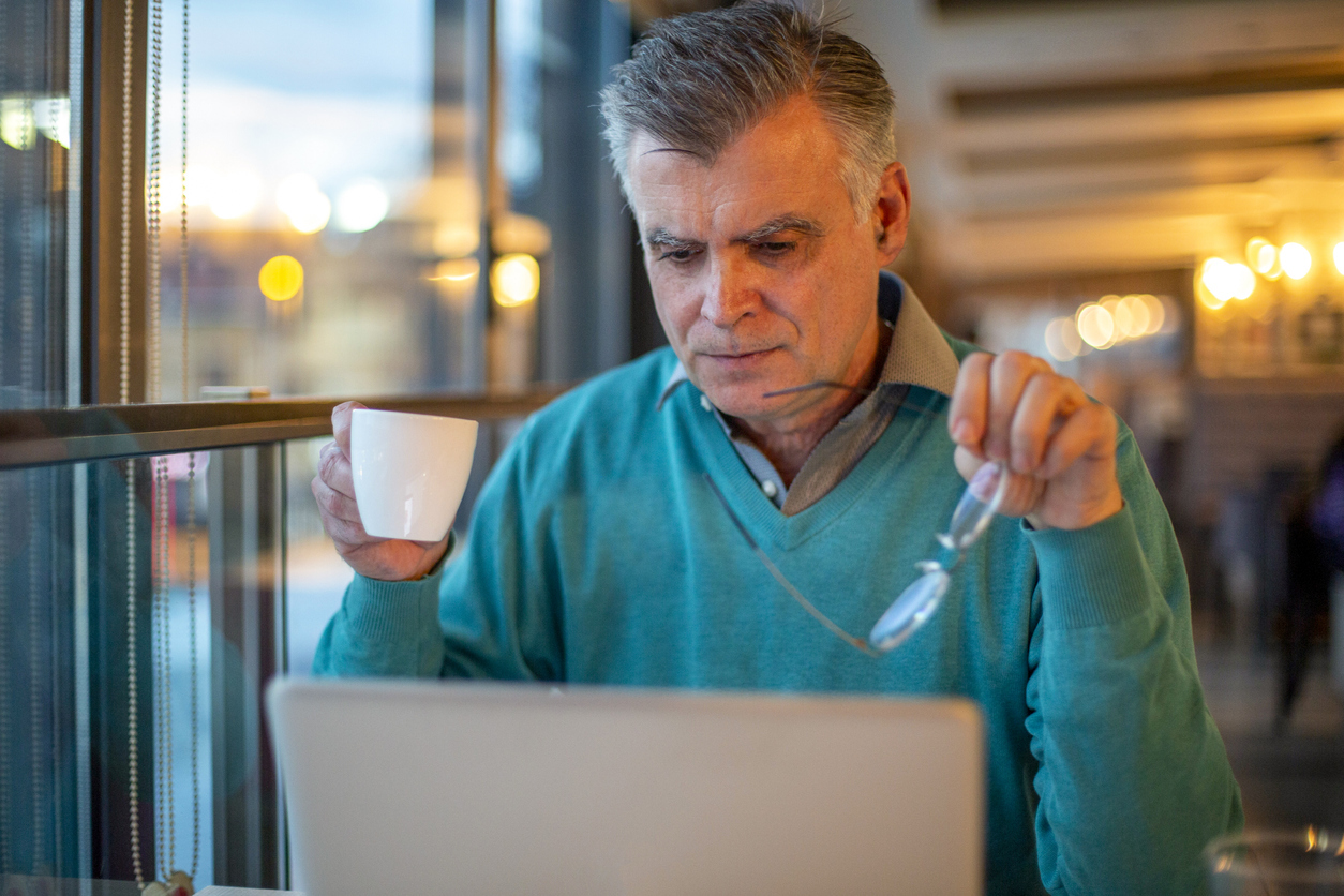 older man reading news on his computer