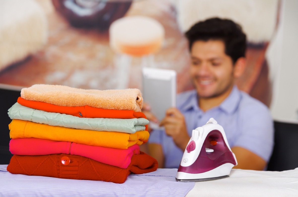 man reading manual while doing laundry