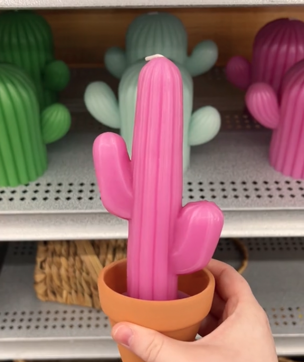 shopper holding up a pink cactus-shaped candle at Michaels