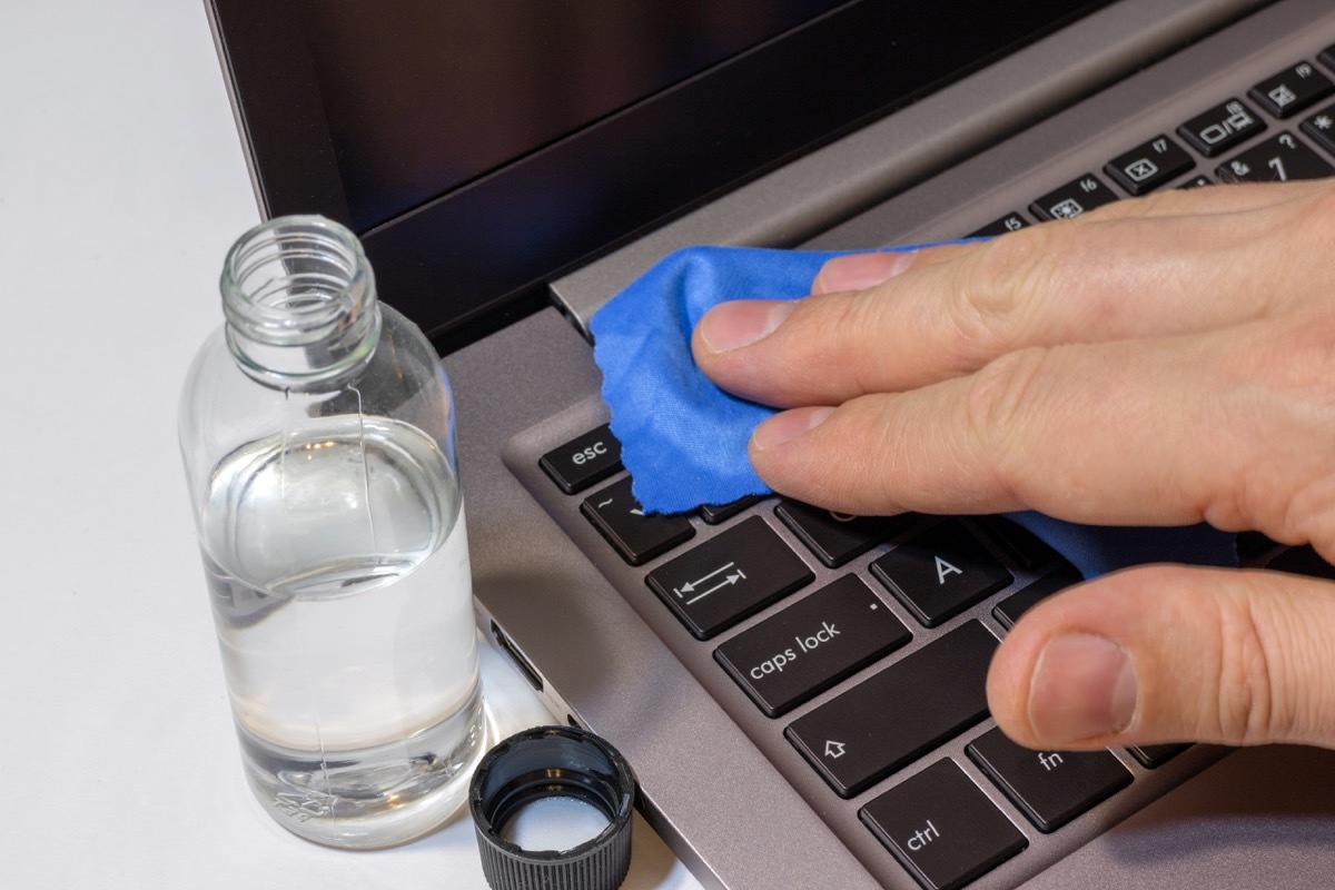 Person cleaning a laptop keyboard