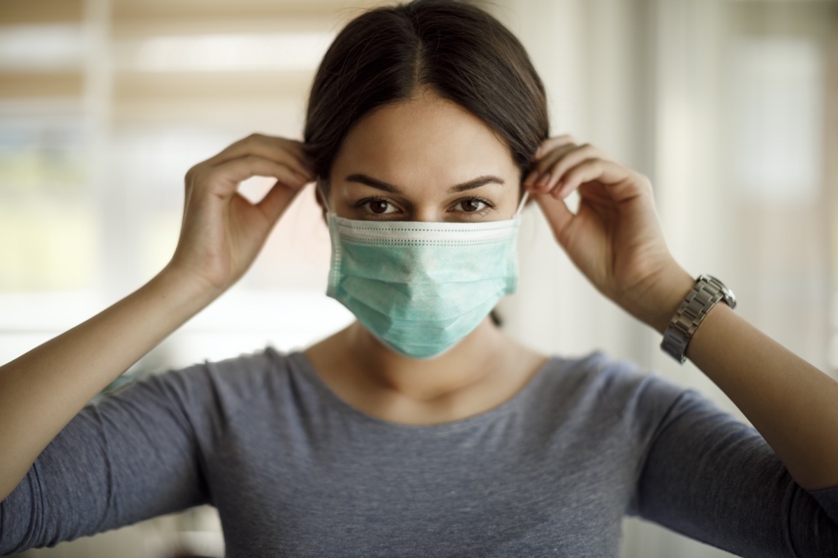 Woman putting on a protective mask