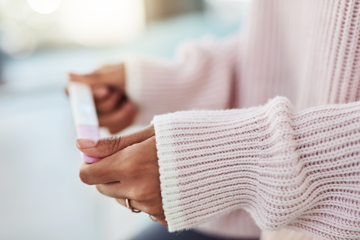 woman holding a pregnancy test up close