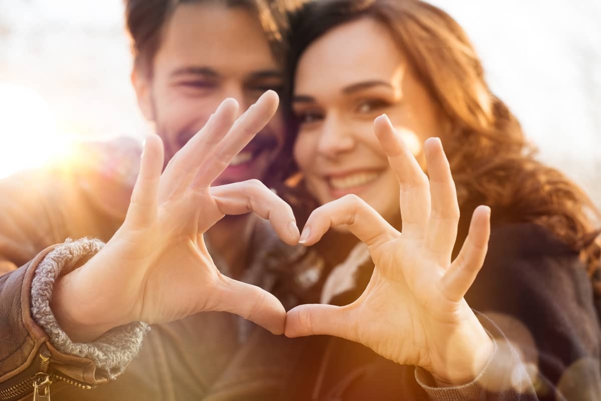 i love you quotes: young couple making a heart of their hands