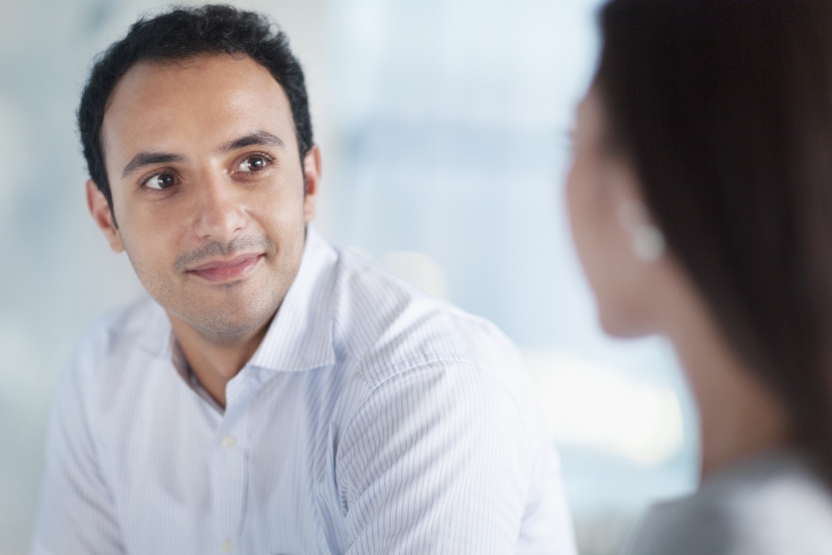 Young man looking at colleague in office