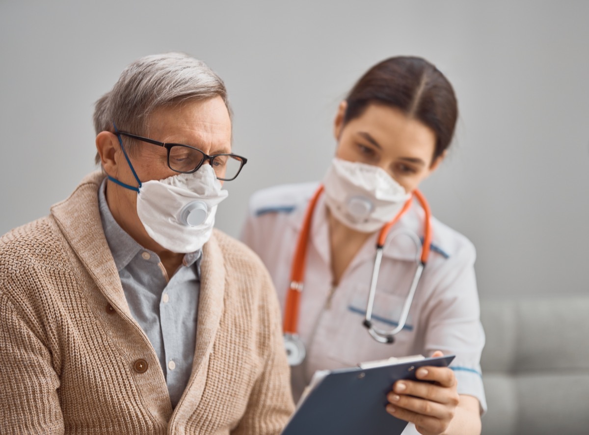 Older patient wearing a mask with nurse