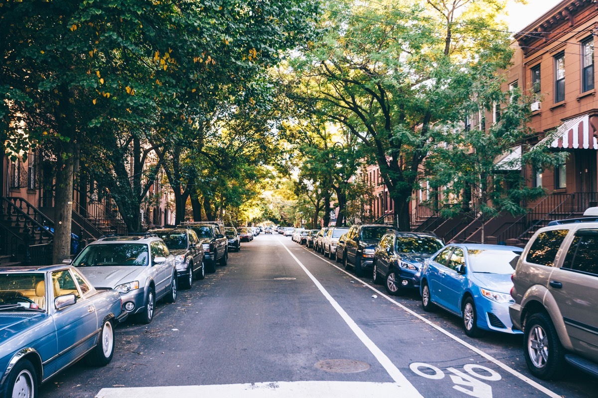 street with cars parked alongside in front of houses