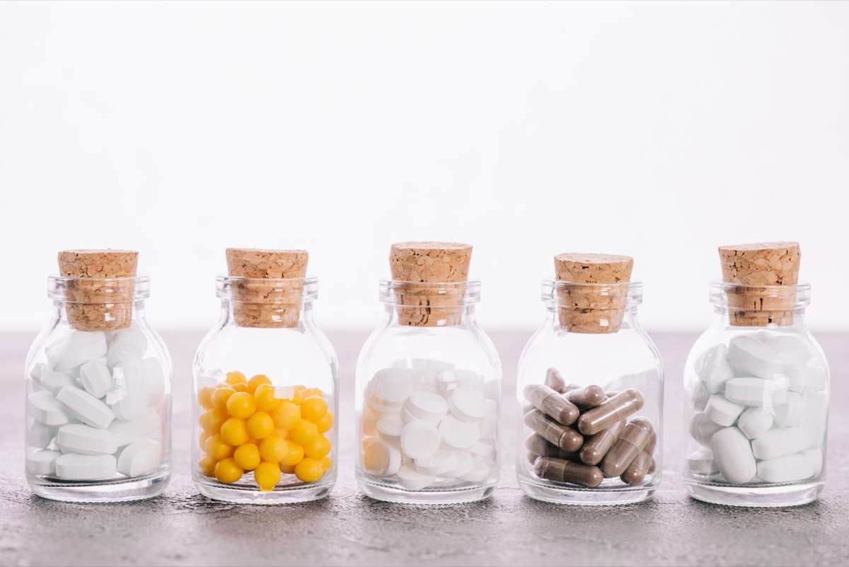 Row of jar bottles filled with various pills including probiotics