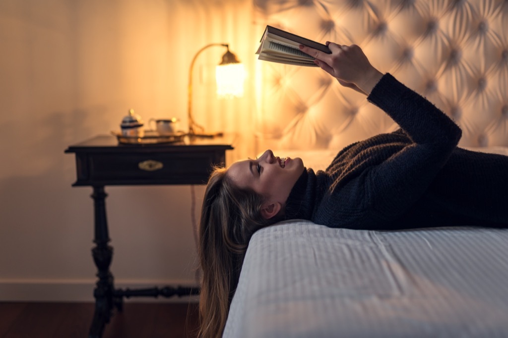 clean sleeping woman reading a book a bed