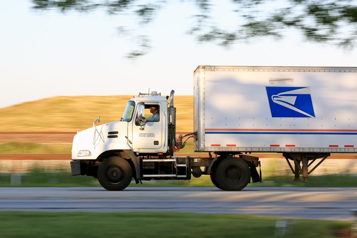 United States Postal Service truck on the road in the suburbs of Chicago transporting packages.