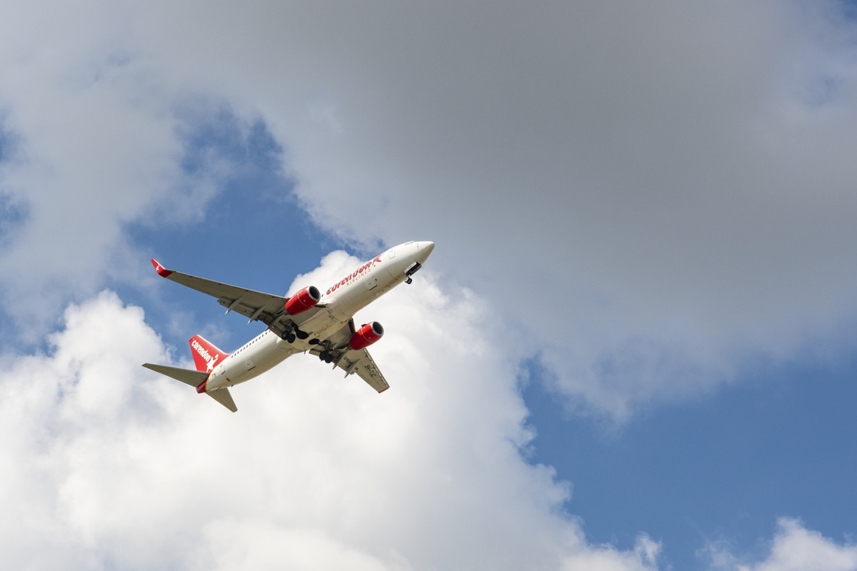 Corendon Airlines Boeing 737 airplane approaching Düsseldorf airport with clouds in the background.