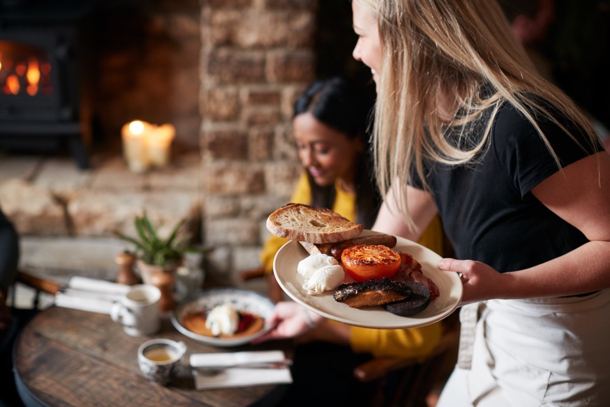 closeup of a woman serving plates in a restaurant