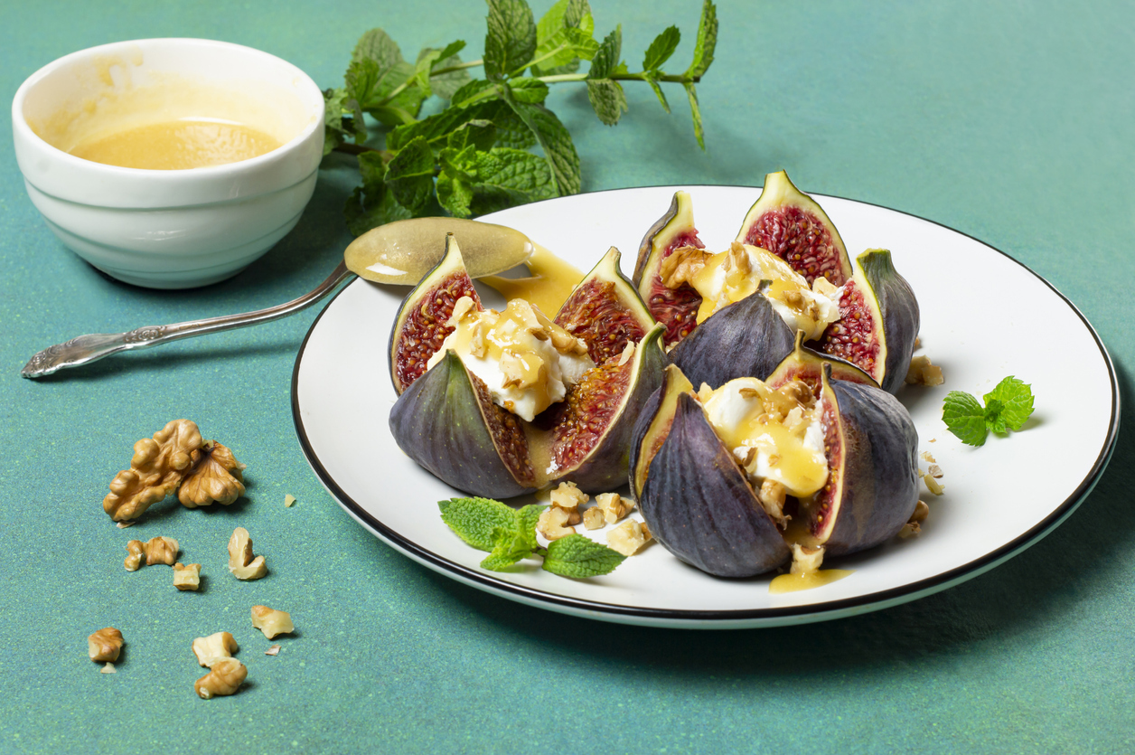 Ripe figs stuffed with cream cheese with honey sauce and walnuts. 