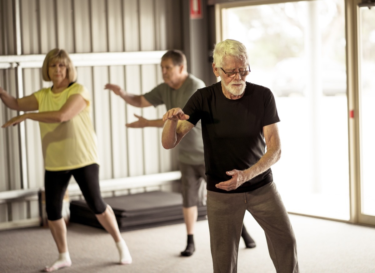 Group of seniors in Tai Chi class exercising in an active retirement lifestyle. Mental and physical health benefits of exercise and fitness in elderly people. Senior health care and wellbeing concept.