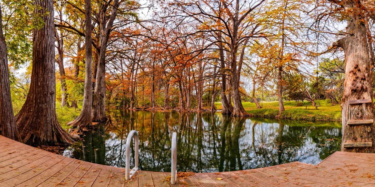 swimming hole with fall foliage around it