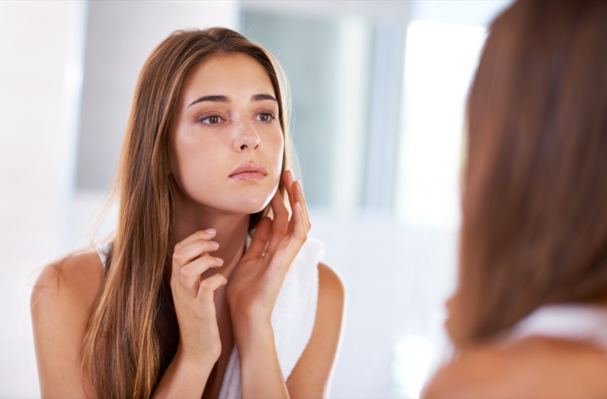 Woman looking at her reflection in a mirror.