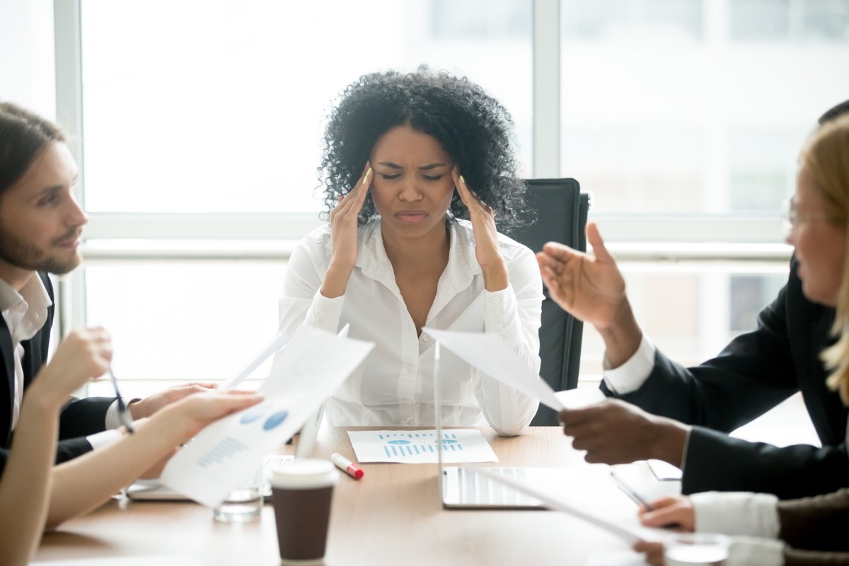 Woman stressed at her desk at work, things husband should notice