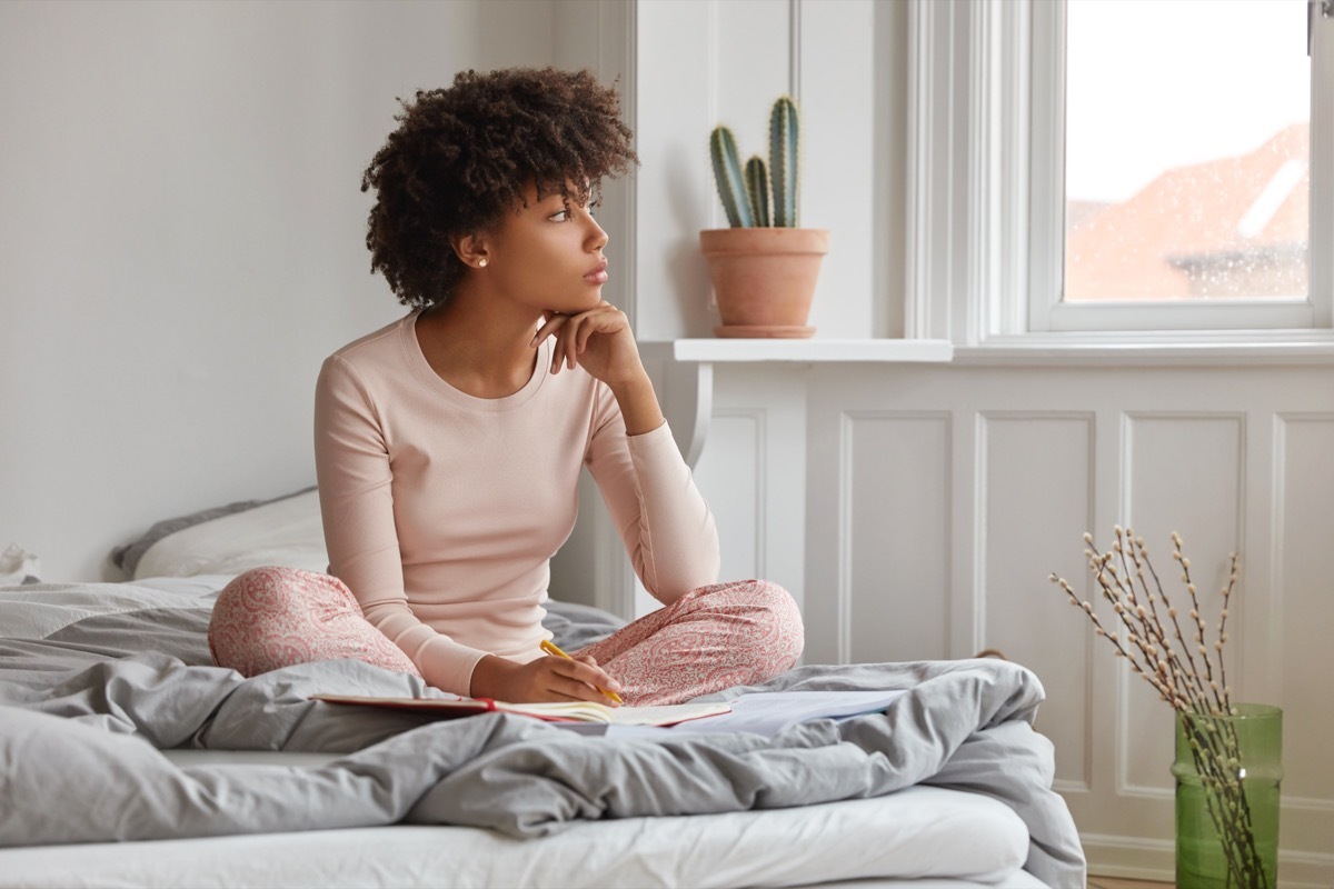 Woman manifesting looking out her window. 