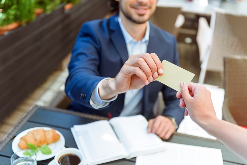 Man handing woman card