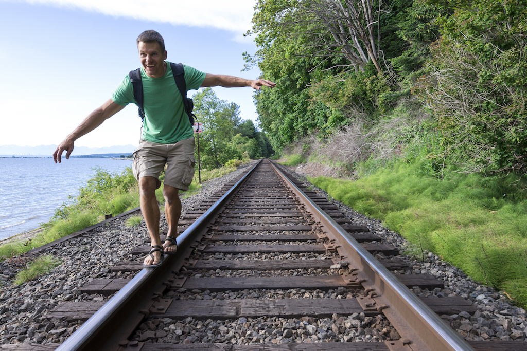 man walking on train tracks in cargo shorts, how to dress over 40