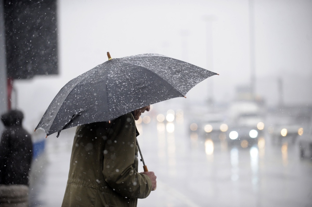 man carrying umbrella rainy day