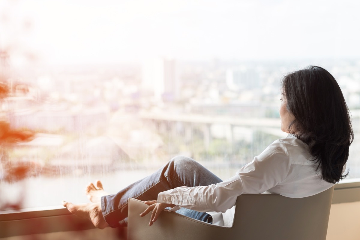 woman looking outside on balcony