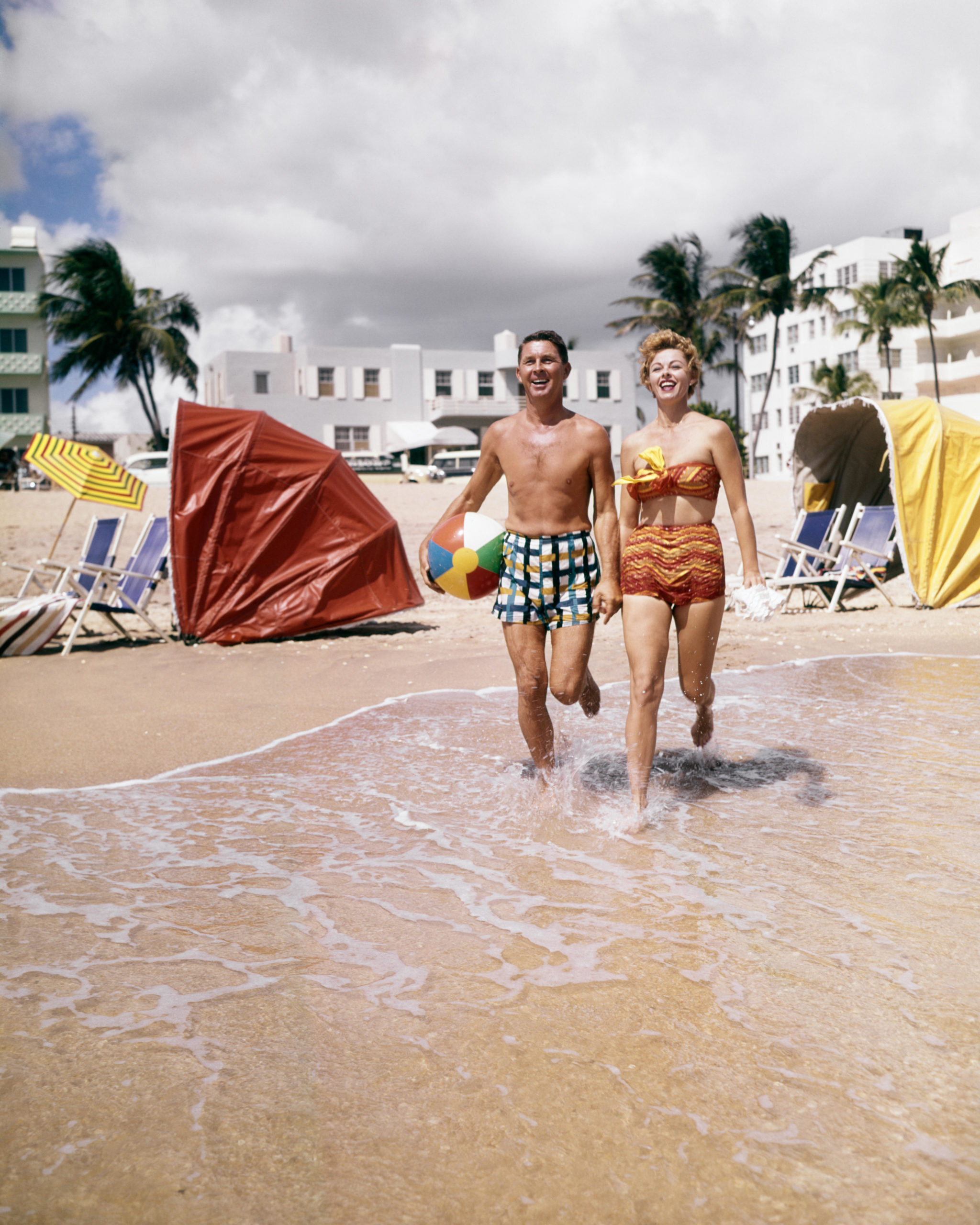 a man and women walk into the waves in the 1960s