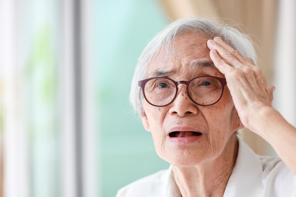 older woman holding head