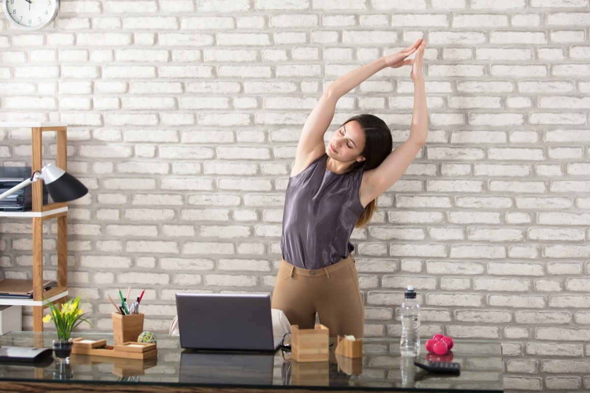 Woman stretching at her desk