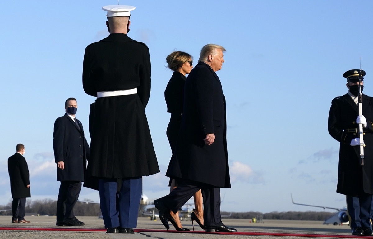 donald and melania trump walk past armed service members on the way to air force one